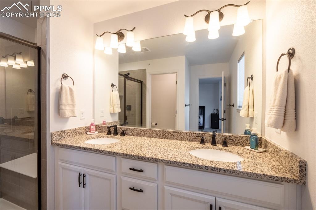 15619 Kitchener Way Monument, CO 80132 - Photo 24 of 40 a bathroom with a granite countertop sink double vanity and a mirror