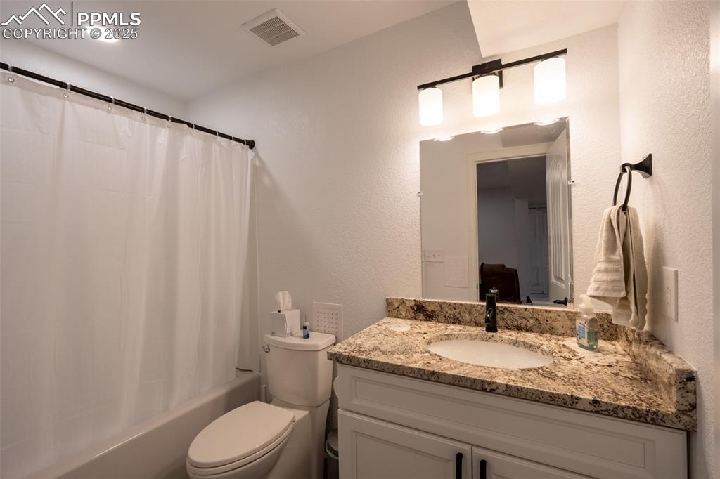 15619 Kitchener Way Monument, CO 80132 - Photo 33 of 40 a bathroom with a granite countertop sink toilet and mirror