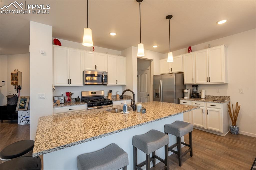 15619 Kitchener Way Monument, CO 80132 - Photo 7 of 40 a kitchen with granite countertop a sink a center island stainless steel appliances and cabinets