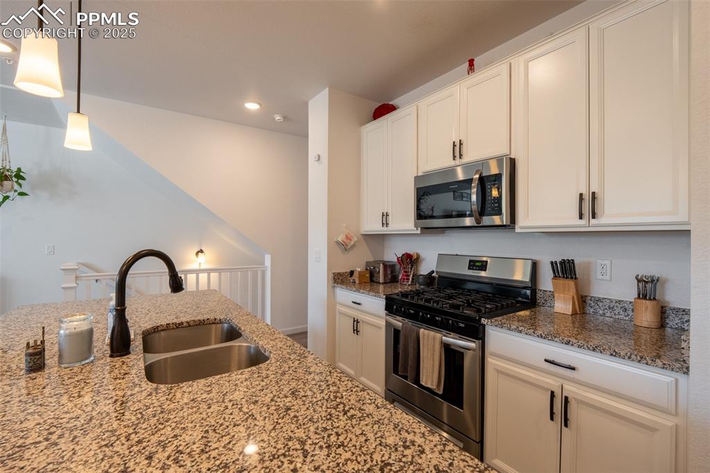 15619 Kitchener Way Monument, CO 80132 - Photo 10 of 40 a kitchen with granite countertop a sink stainless steel appliances and cabinets