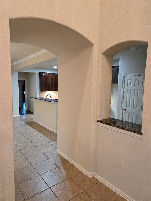 213 Willet Court Little Elm, TX 75068 - Photo 10 of 28 Hall with arched walkways, light tile patterned flooring, ornamental molding, and recessed lighting