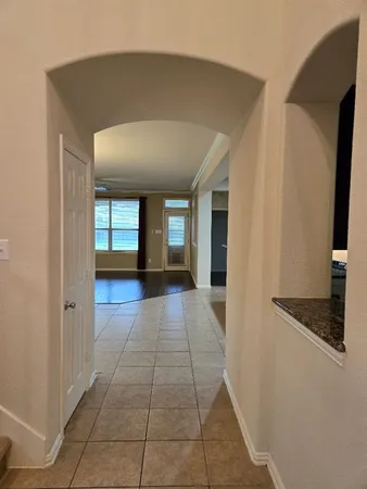 a view of a hallway with wooden floor and a living room