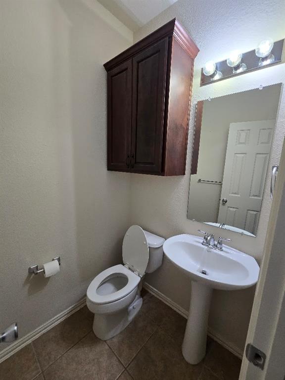 213 Willet Court Little Elm, TX 75068 - Photo 12 of 28 Half bathroom featuring toilet and dark tile patterned flooring