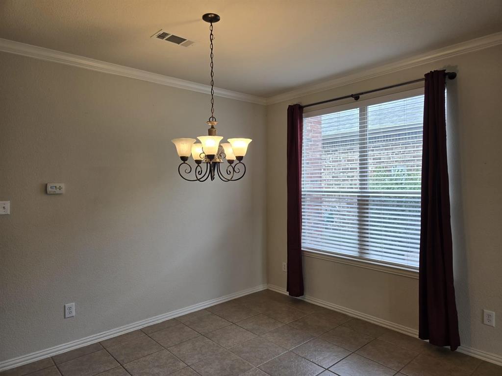 213 Willet Court Little Elm, TX 75068 - Photo 14 of 28 Spare room featuring ornamental molding, a chandelier, and light tile patterned floors