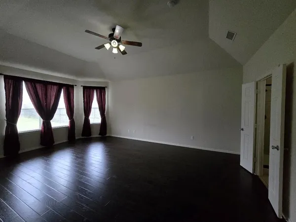 a view of a livingroom with a chandelier a ceiling fan and a window