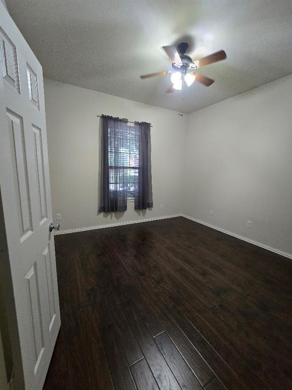 213 Willet Court Little Elm, TX 75068 - Photo 21 of 28 Empty room featuring dark wood-type flooring, ceiling fan, and a textured ceiling