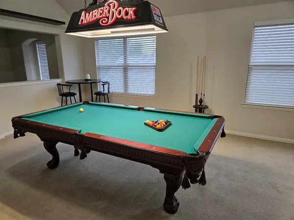 a room with pool table and windows