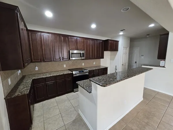 a kitchen with granite countertop a stove and a sink
