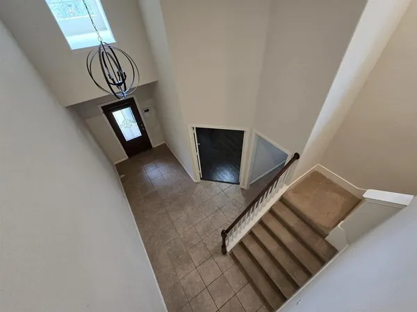 a view of a hallway with entryway and stairs