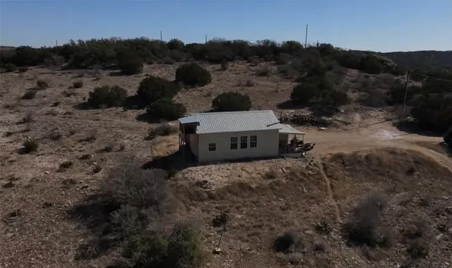 a view of a houses in a big yard