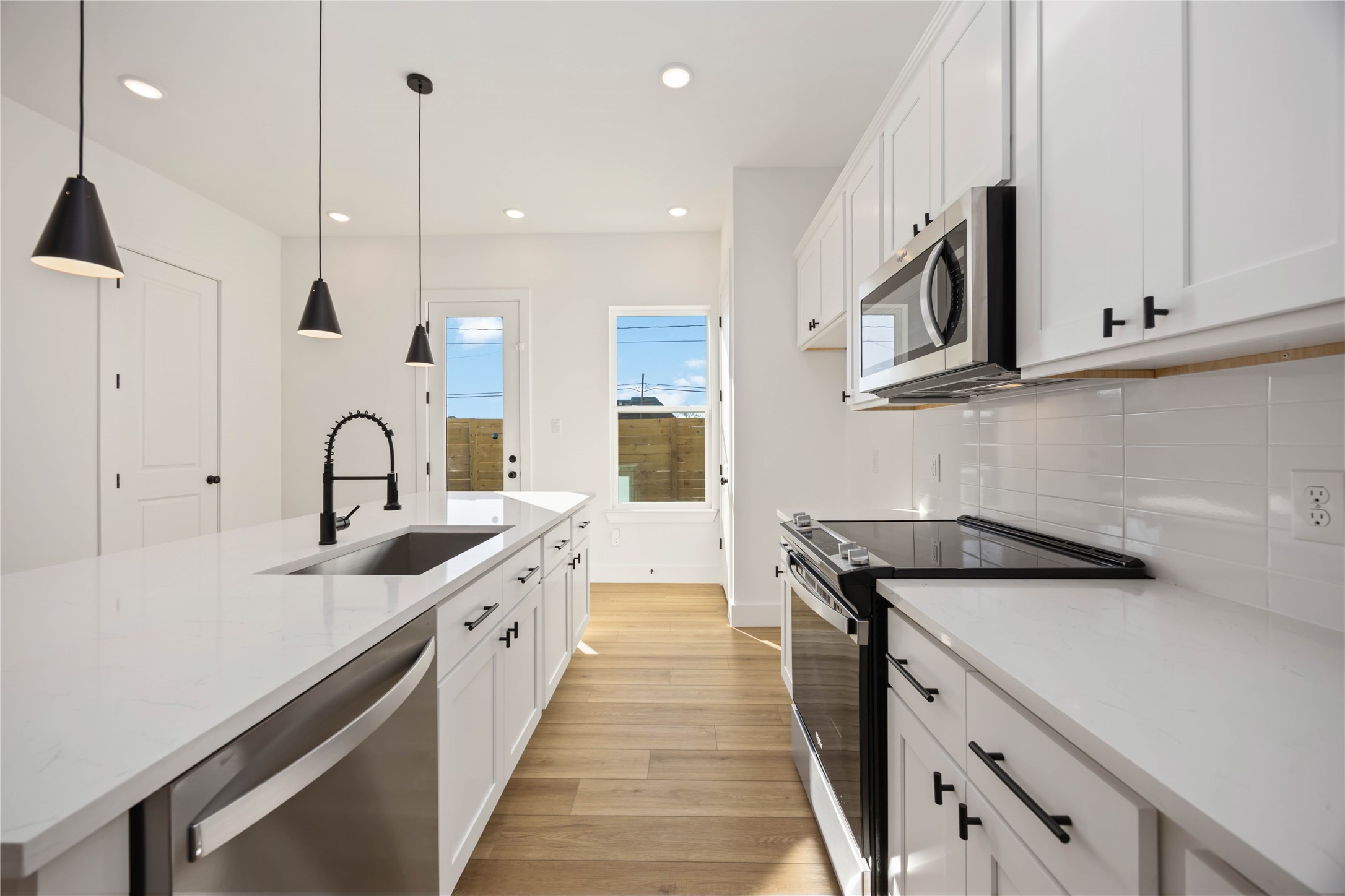 1466 Ferguson Way, Unit B Houston, TX 77088 - Photo 11 of 28 a kitchen with a sink and white cabinets