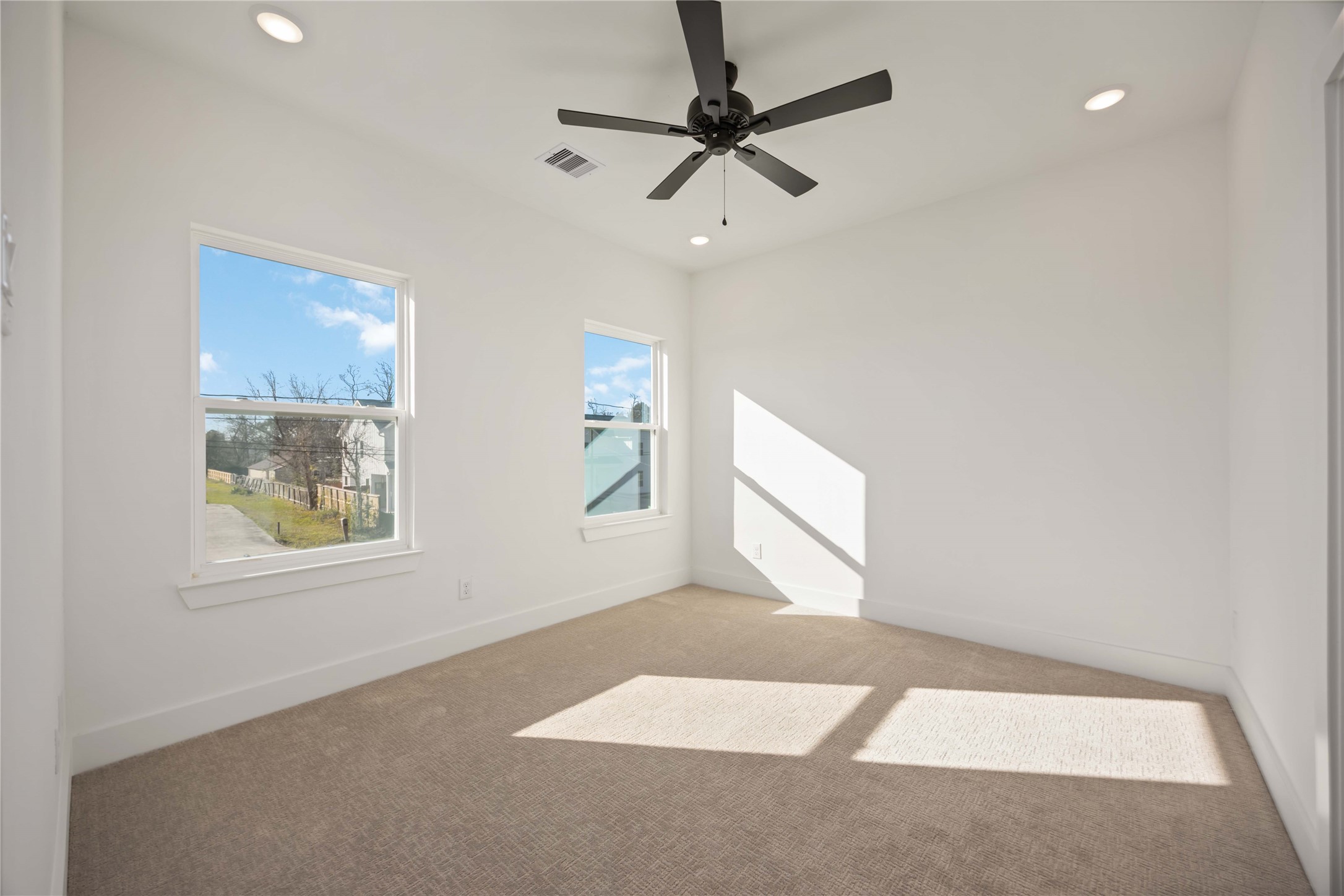 1466 Ferguson Way, Unit B Houston, TX 77088 - Photo 16 of 28 an empty room with windows and fan