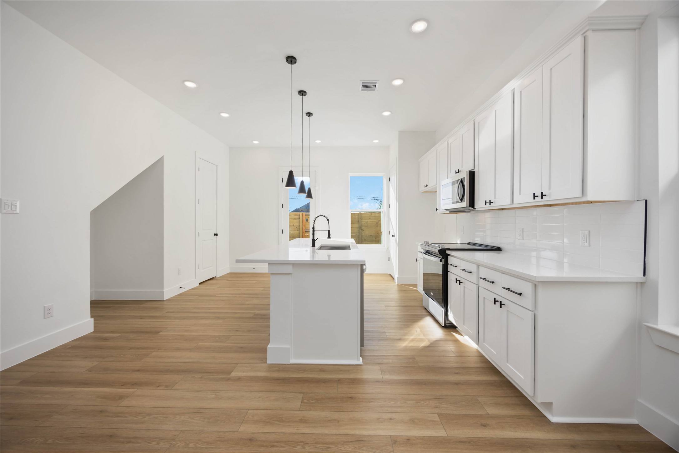 1466 Ferguson Way, Unit B Houston, TX 77088 - Photo 9 of 28 a large kitchen with stainless steel appliances granite countertop a stove top oven a sink and white cabinets