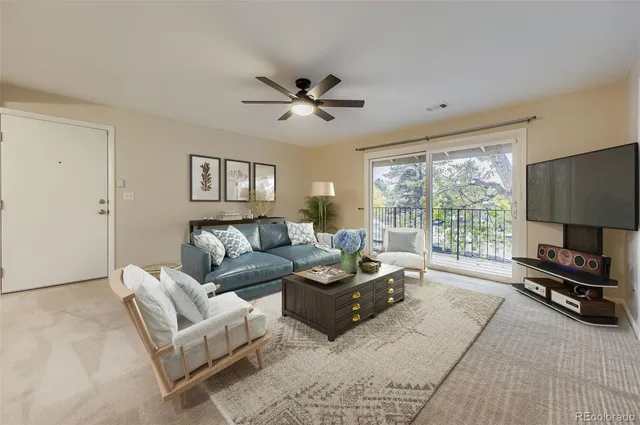 a living room with furniture a large window and a flat screen tv