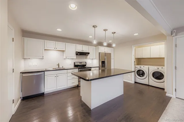 a kitchen with stainless steel appliances granite countertop a stove a sink and a refrigerator