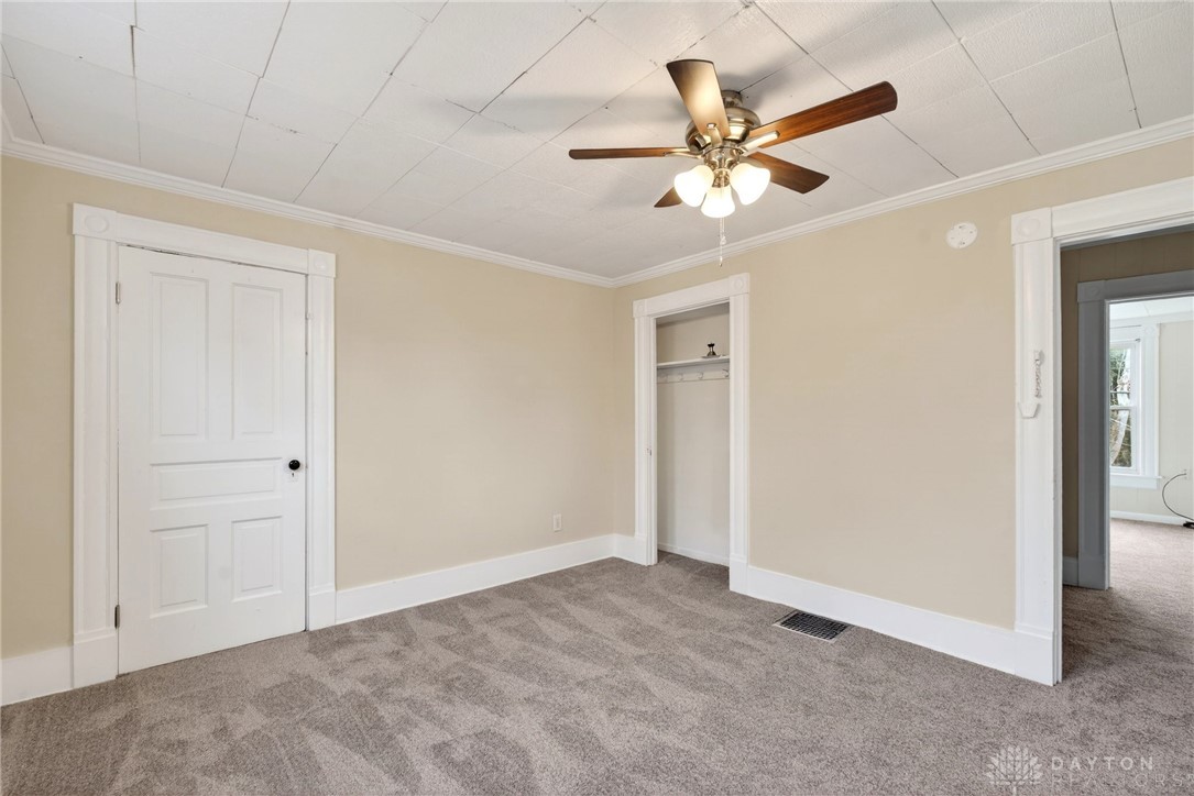 585 North Spring Street Wilmington, OH 45177 - Photo 19 of 21 This cozy bedroom features plush carpeting and a convenient closet, ideal for comfortable living.