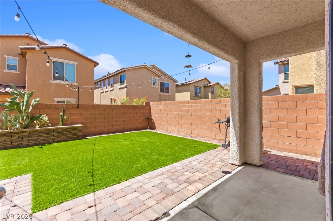 6435 Point Isabel Way Las Vegas, NV 89122 - Photo 41 of 57 A private, low-maintenance backyard retreat featuring artificial turf and brick pavers for year-round enjoyment.