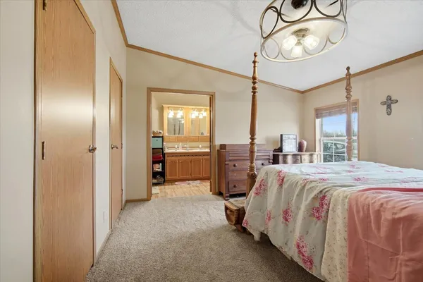 a spacious bedroom with a bed and a chandelier