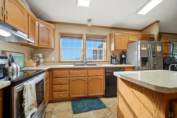 a kitchen with stainless steel appliances granite countertop a sink stove and refrigerator