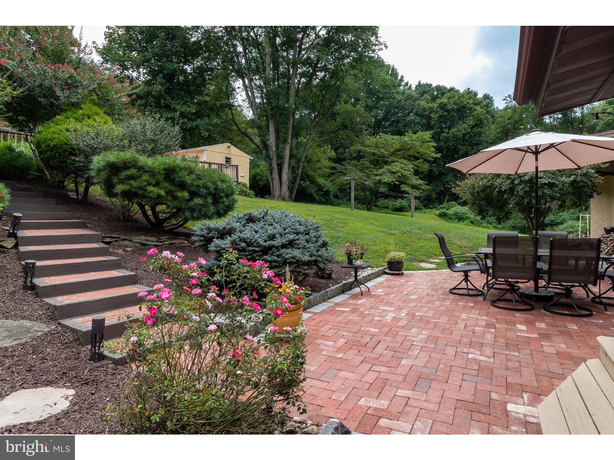 246 Chesterville Road Landenberg, PA 19350 - Photo 21 of 62 a view of a backyard with plants and a bench