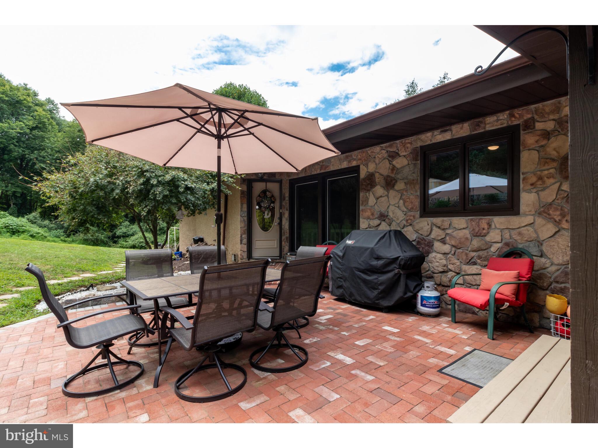 246 Chesterville Road Landenberg, PA 19350 - Photo 23 of 62 a view of a patio with table and chairs under an umbrella