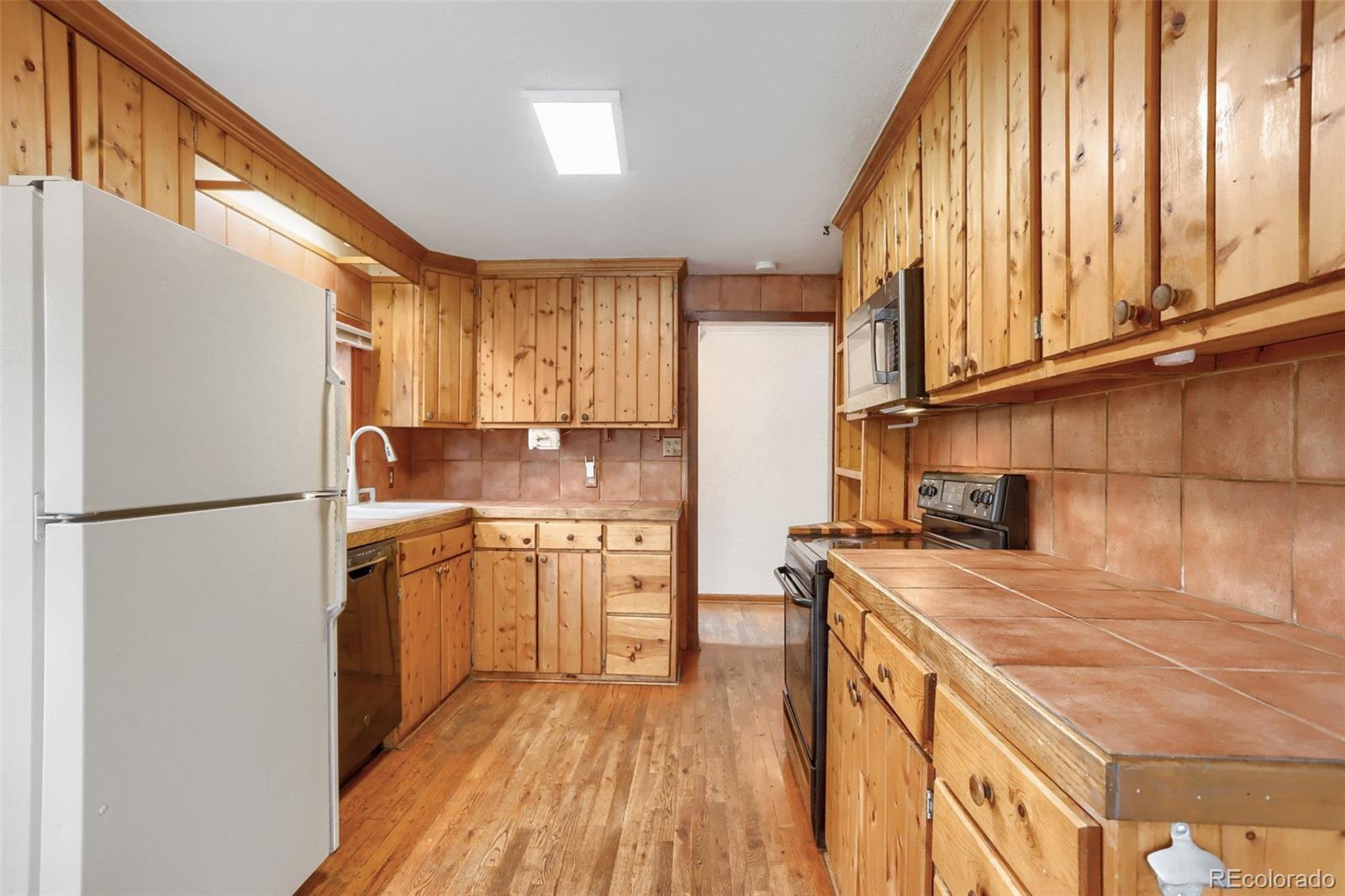 2 Debra Ann Road Golden, CO 80403 - Photo 14 of 41 a kitchen with a refrigerator a sink and dishwasher with wooden floor