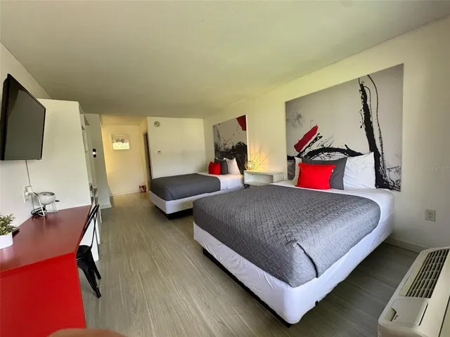 a bedroom with two beds and a desk