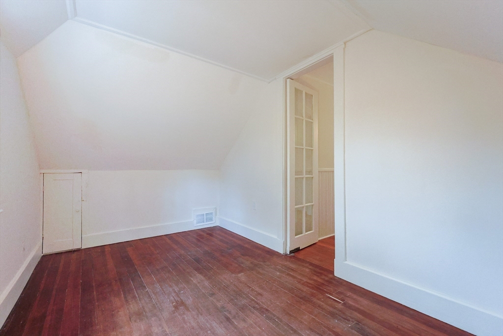 52 Harrison Street Medford, MA 02155 - Photo 34 of 42 an empty room with wooden floor and white walls