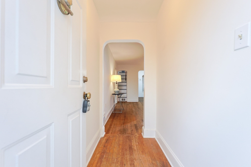 52 Harrison Street Medford, MA 02155 - Photo 7 of 42 a view of a hallway with wooden floor and a bathroom