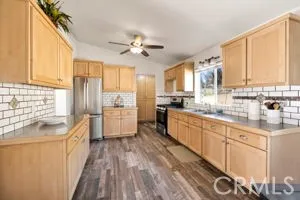 a large kitchen with kitchen island granite countertop a large window a sink and stainless steel appliances