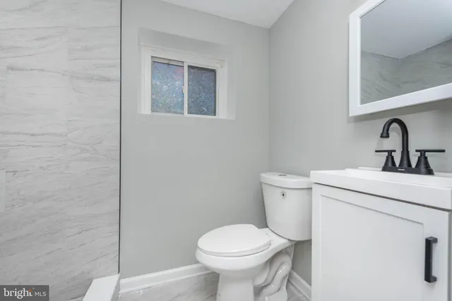 a bathroom with a toilet sink and mirror
