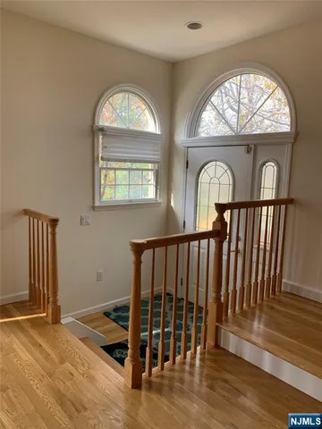 an empty room with wooden floor fan and a window