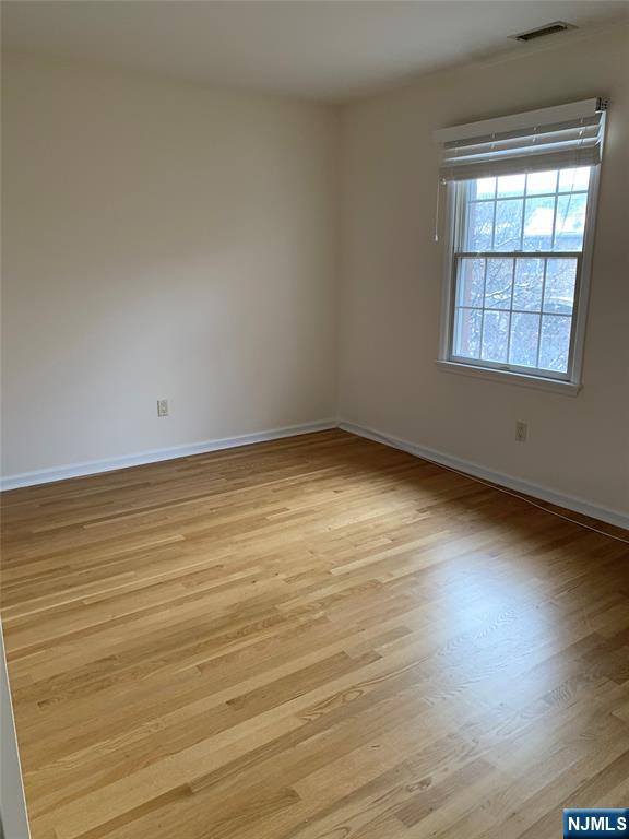166 Stonegate Trail Cresskill, NJ 07626 - Photo 14 of 28 an empty room with wooden floor and windows