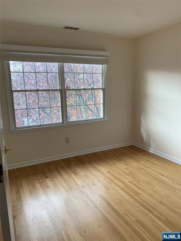 166 Stonegate Trail Cresskill, NJ 07626 - Photo 16 of 28 an empty room with wooden floor and windows
