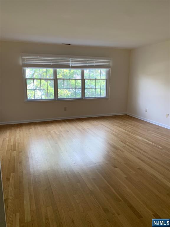 166 Stonegate Trail Cresskill, NJ 07626 - Photo 18 of 28 an empty room with wooden floor and windows