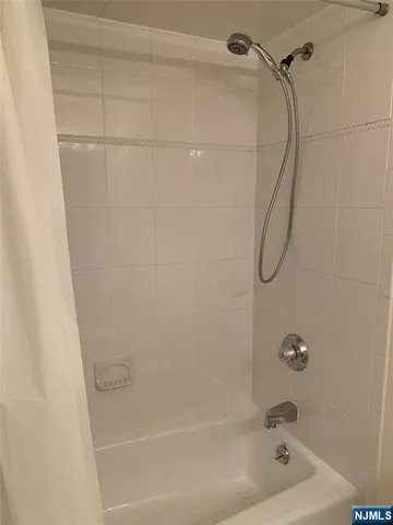 a bathroom with a bath tub with a shower