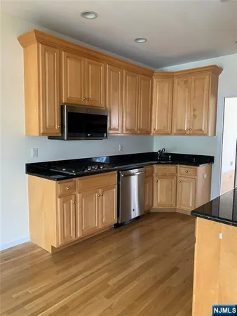 a kitchen with granite countertop wooden cabinets a sink and dishwasher