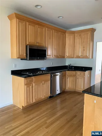 a kitchen with granite countertop wooden cabinets a sink and dishwasher