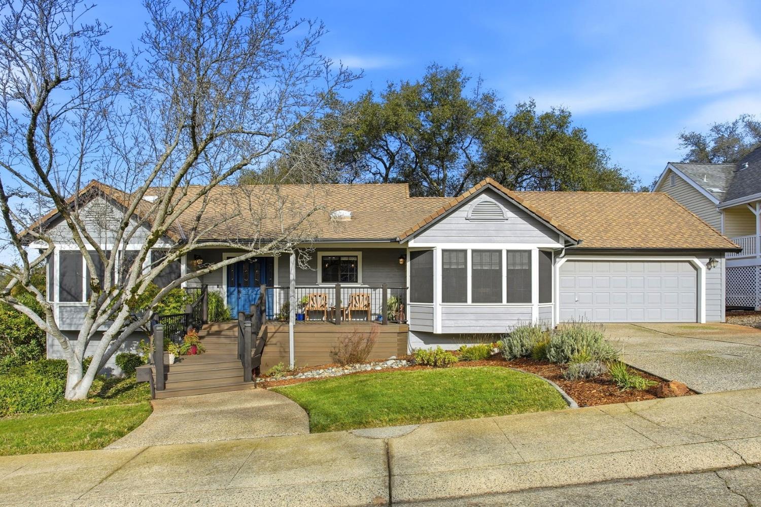 a front view of a house with a yard and potted plants