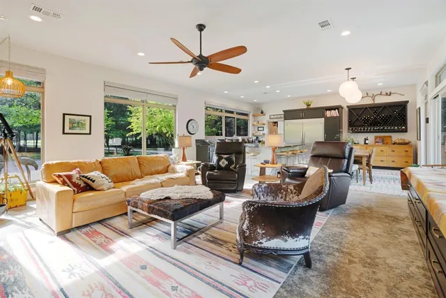 a living room with fireplace furniture and a large window