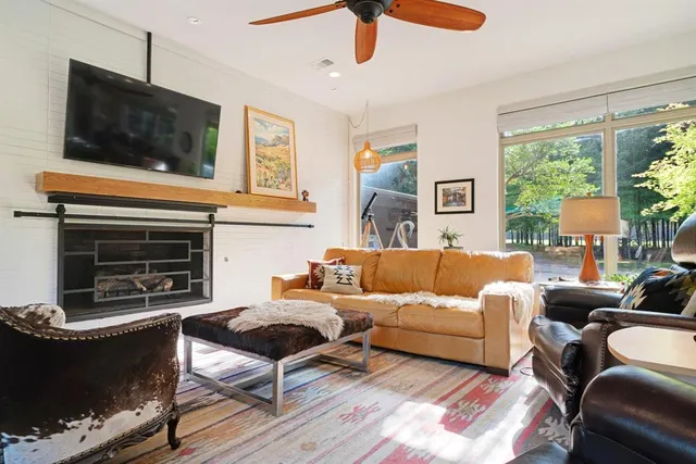 a living room with furniture a flat screen tv and a fireplace