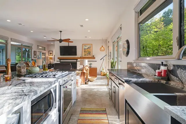 a kitchen with stainless steel appliances granite countertop a stove and a sink