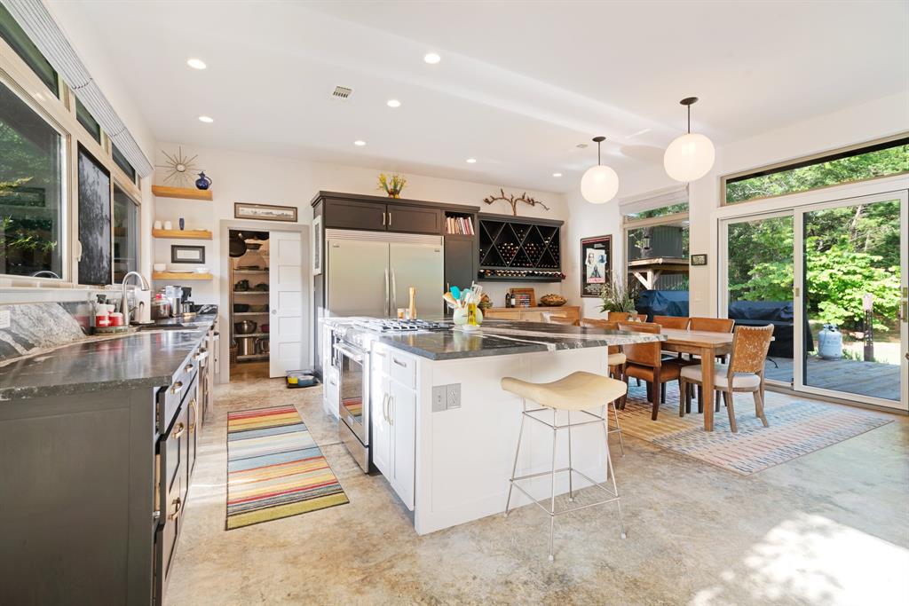 323 County Road Powderly, TX 75473 - Photo 9 of 36 a kitchen with stainless steel appliances kitchen island granite countertop a sink and a refrigerator