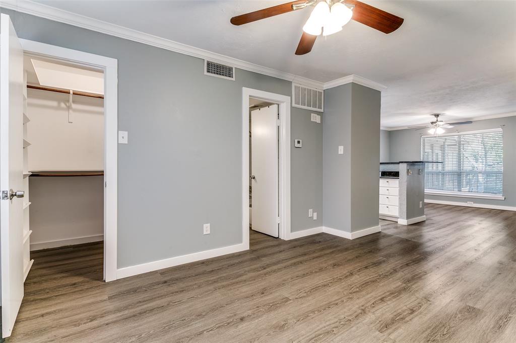 4525 Gilbert Avenue, Unit 203 Dallas, TX 75219 - Photo 5 of 6 a view of a hallway with wooden floor and a kitchen