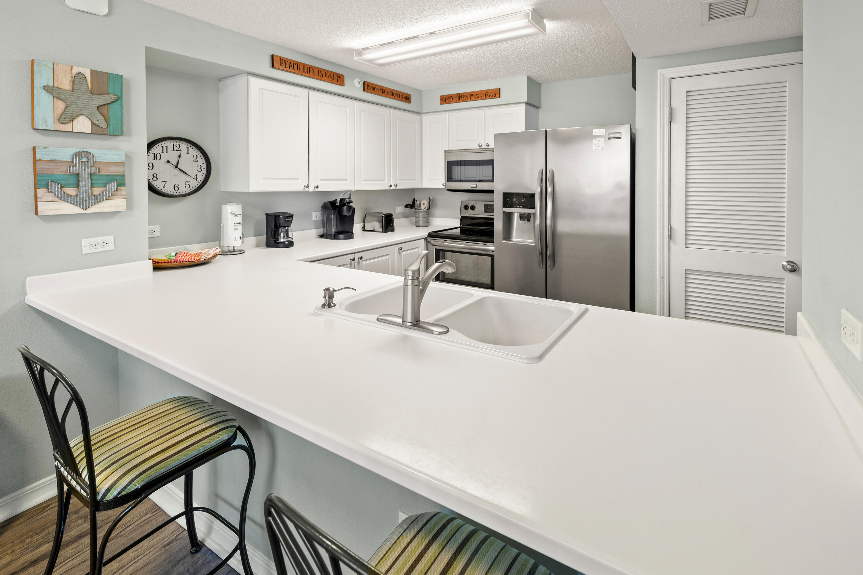 520 Santa Rosa Boulevard, Unit 319 Fort Walton Beach, FL 32548 - Photo 12 of 43 a kitchen with stainless steel appliances a white refrigerator a sink dishwasher with a dining table and chairs