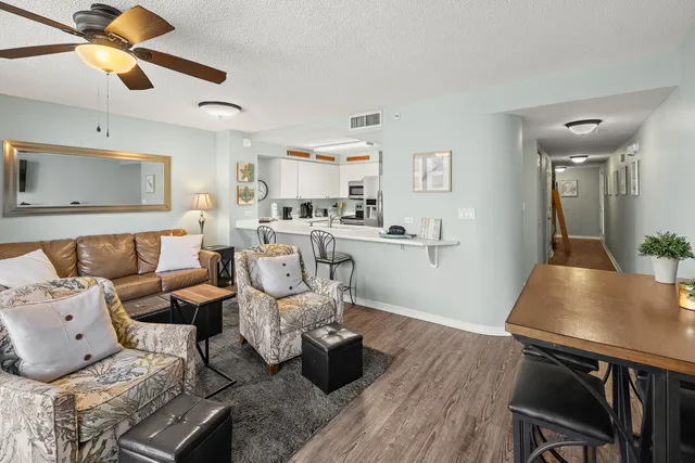 a kitchen with stainless steel appliances a dining table chairs and a refrigerator