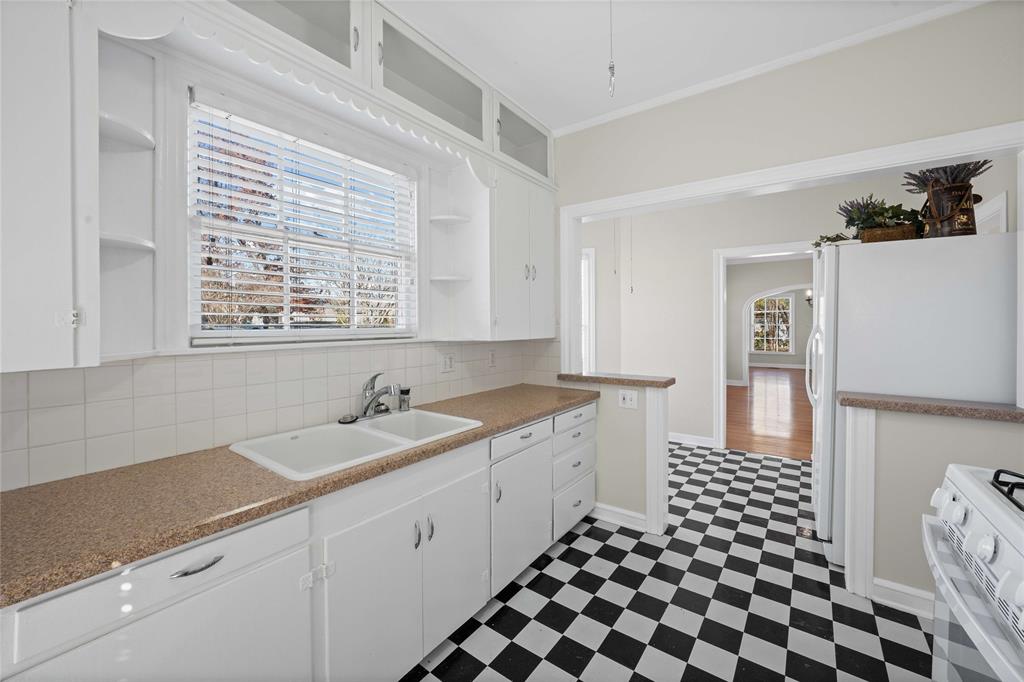 1919 North 7th Street Temple, TX 76501 - Photo 16 of 36 a kitchen with a sink a stove a refrigerator and white cabinets