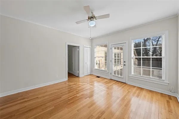 a view of an empty room with a window and wooden floor