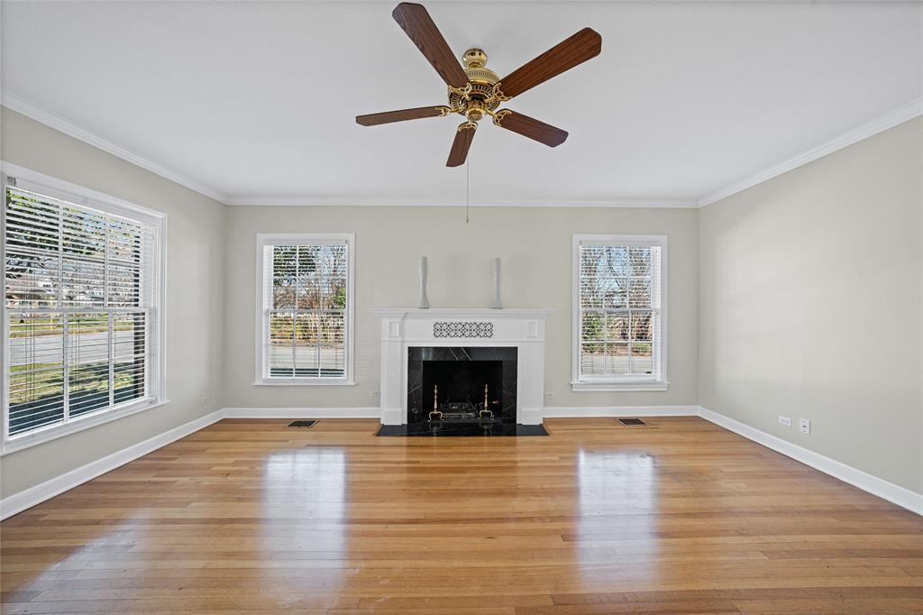 1919 North 7th Street Temple, TX 76501 - Photo 7 of 36 an empty room with windows fireplace and wooden floor