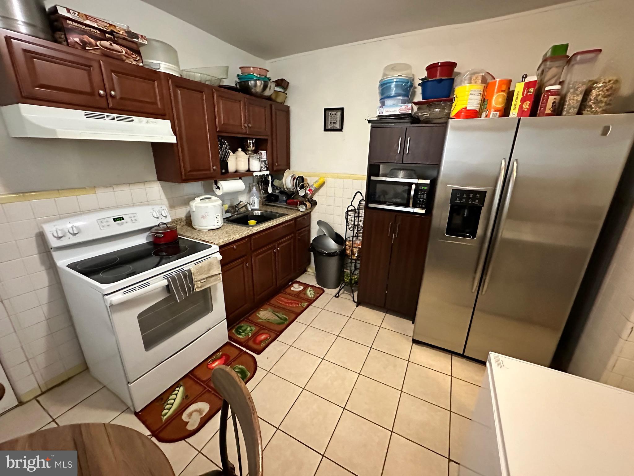 6148 Reedland Street Philadelphia, PA 19142 - Photo 5 of 20 a kitchen with stainless steel appliances a stove a refrigerator and a sink